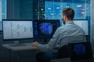 Man at computer with several screens